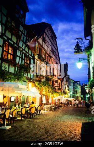 Rue et terrasses de cafés dans la vieille ville la nuit, Riquewihr, Alsace, France Banque D'Images