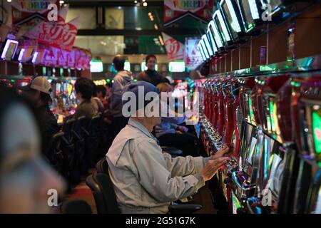 Un vieil homme jouant du pachinko à Osaka, au Japon Banque D'Images