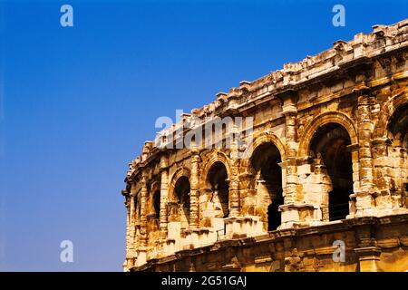 Ancien amphithéâtre romain de l'Arena de Nîmes contre ciel clair, Nîmes, France Banque D'Images