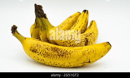 quatre bananes marron jaune sur fond blanc Banque D'Images