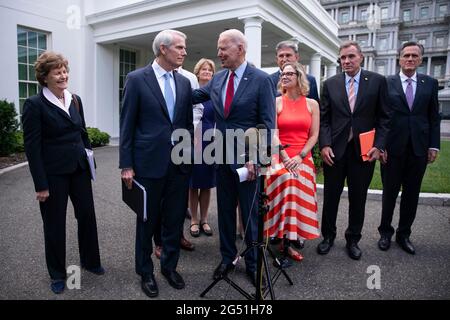 Le président des États-Unis Joe Biden s'adresse au sénateur américain Rob Portman (républicain de l'Ohio), alors qu'il s'adresse à des reporters en dehors de l'aile ouest de la Maison Blanche à la suite d'une réunion avec un groupe bipartisan de sénateurs où ils ont conclu un accord sur le plan d'infrastructure à Washington, DC, jeudi, 24 juin 2021. De gauche à droite : la sénatrice des États-Unis Jeanne Shaheen (démocrate du New Hampshire), le sénateur des États-Unis Rob Portman (républicain de l'Ohio), la sénatrice des États-Unis Lisa Murkowski (républicaine de l'Alaska), le président, le sénateur des États-Unis Kyrsten Sinema (démocrate de l'Arizona), Unite Banque D'Images