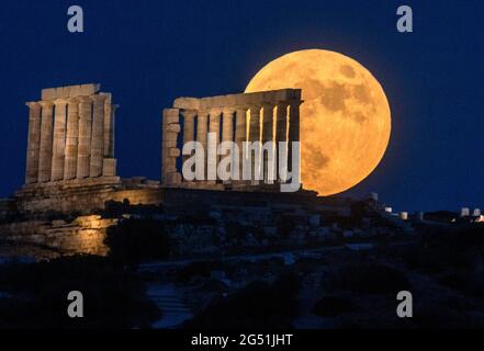 Athènes, Grèce. 24 juin 2021. La pleine lune s'élève au-dessus du temple de Poséidon au cap Sounion, à environ 70 km au sud-est d'Athènes, en Grèce. ©Elias Verdi/Alamy Live News Banque D'Images