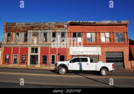 Un pick-up passe le long de la route 66 et passe devant l'ancien hôtel St. Cloud à Chandler, Oklahoma. Le bâtiment historique date du début des années 1900. Banque D'Images