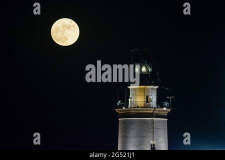 Malaga, Espagne. 24 juin 2021. La pleine super lune, qui s'élève au-dessus d'un phare. Selon la NASA, la « lune de chaluts » est la dernière super lune de l'année 2021. Son nom est originaire des Amérindiens, qui ont cueilli des fraises pendant la récolte. Crédit : SOPA Images Limited/Alamy Live News Banque D'Images