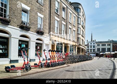 E-trottinettes (scooters électriques) et bicyclettes garées sur la rue St Mary's, Cambridge, Angleterre. Banque D'Images