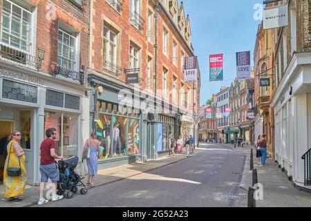 Les amateurs de shopping se prominent le long de Trinity Street, à Cambridge, en Angleterre, lors d'une journée ensoleillée d'été. Banque D'Images