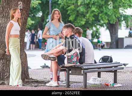 Adolescents amis assis sur le banc, bavardant et s'amusant dans la ville pendant le printemps ou l'été, Covid ou coronavirus temps Banque D'Images