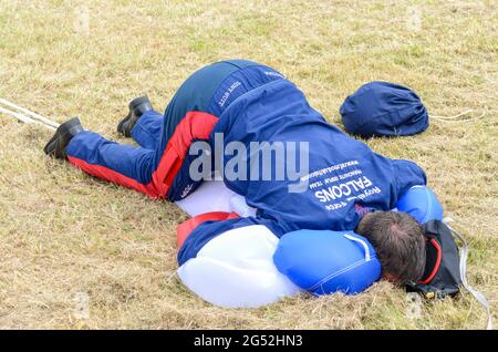 Parachutiste de l'équipe de parachutistes de la Royal Air Force Falcons en train de pousser son corps dans un parachute pour le comprimer après l'atterrissage Banque D'Images