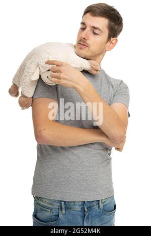 Jeune beau grand homme blanc mince avec cheveux bruns chemise grise en Jean bleu avec mouflon sur l'épaule isolé sur fond blanc Banque D'Images