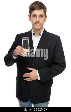 Jeune beau grand homme blanc mince avec cheveux bruns avec verre d'eau dans blazer noir isolé sur fond blanc Banque D'Images