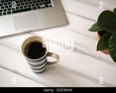 Bureau en bois blanc avec carnet et grande tasse de café Banque D'Images