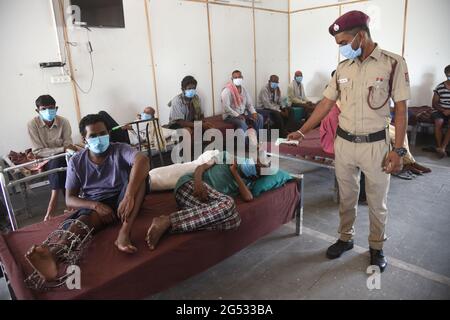 New Delhi, Inde. 25 juin 2021. Un agent de sécurité vérifie la température d'un détenu avant de l'inscrire à une campagne de vaccination gratuite pour les sans-abri dans un camp de la zone de remblai de la rivière Yamuna à New Delhi, Inde, le vendredi 24 juin 2021. Photo de Sondeep Shankar/ Pacific Press (photo de Sondeep Shankar/Pacific Press) Credit: Pacific Press Media production Corp./Alay Live News Banque D'Images