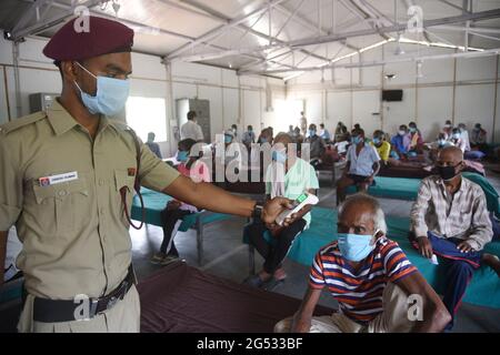 New Delhi, Inde. 25 juin 2021. Un agent de sécurité vérifie la température d'un détenu avant de l'inscrire à une campagne de vaccination gratuite pour les sans-abri dans un camp de la zone de remblai de la rivière Yamuna à New Delhi, Inde, le vendredi 24 juin 2021. Photo de Sondeep Shankar/ Pacific Press (photo de Sondeep Shankar/Pacific Press) Credit: Pacific Press Media production Corp./Alay Live News Banque D'Images