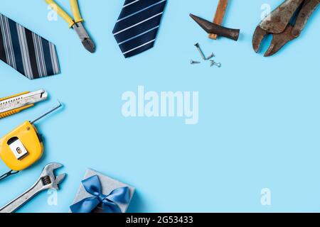 Vue de dessus concept de la fête des pères et de la fête du travail avec des outils de travail sur fond bleu. Banque D'Images