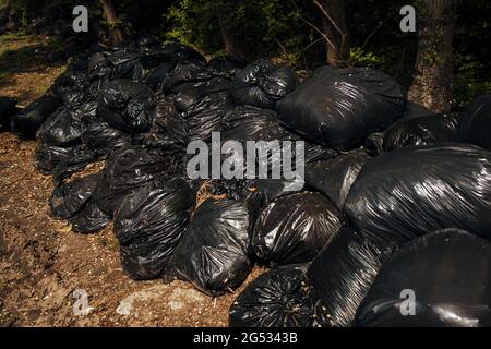 il y a plein de sacs à ordures sur la route par une belle journée d'été Banque D'Images