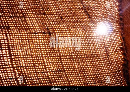 La lumière brille à travers la texture de la toile de sac ou de la toile de jute rugueuse Banque D'Images