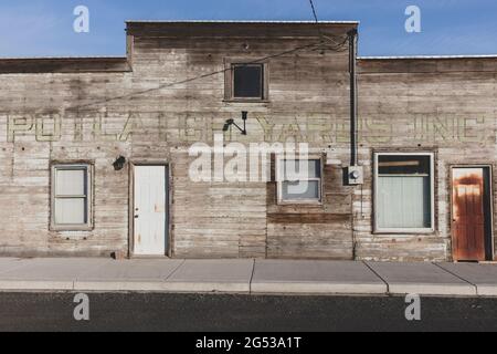 Ancien bâtiment en bois sur la rue principale, porte rouillée et fenêtres à bord. Banque D'Images