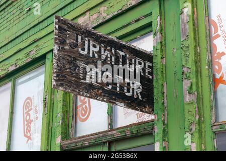 Bâtiment abandonné sur une rue principale, panneau de médecin de meubles au-dessus de la porte d'entrée, atelier de réparation Banque D'Images