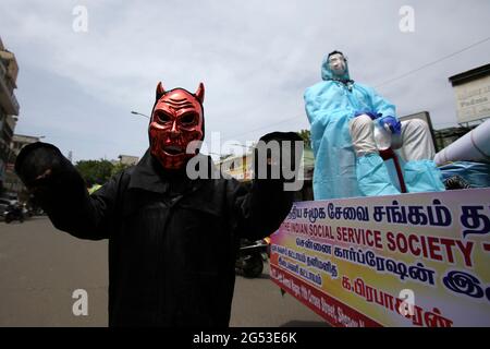 Chennai, Tamil Nadu, Inde. 25 juin 2021. Un membre d'une organisation non gouvernementale vêtu comme un démon ressemblant au coronavirus Covid-19 participe à une campagne de sensibilisation contre la propagation du coronavirus Covid-19 dans une rue de Chennai. Crédit : Sri Loganathan/ZUMA Wire/Alay Live News Banque D'Images