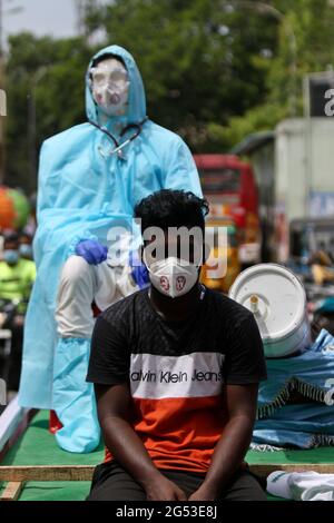 Chennai, Tamil Nadu, Inde. 25 juin 2021. Des membres d'une organisation non gouvernementale ont vu porter un mannequin avec un équipement de protection individuelle (EPI) sur un pousse-pousse à vélo au cours d'une campagne de sensibilisation contre la propagation du coronavirus Covid-19 dans une rue de Chennai. Crédit : Sri Loganathan/ZUMA Wire/Alay Live News Banque D'Images