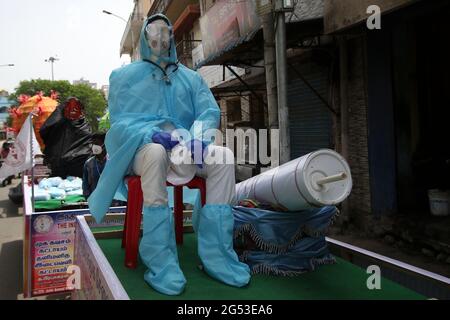 Chennai, Tamil Nadu, Inde. 25 juin 2021. Des membres d'une organisation non gouvernementale ont vu porter un mannequin avec un équipement de protection individuelle (EPI) sur un pousse-pousse à vélo au cours d'une campagne de sensibilisation contre la propagation du coronavirus Covid-19 dans une rue de Chennai. Crédit : Sri Loganathan/ZUMA Wire/Alay Live News Banque D'Images