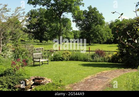 Siège de Bech dans un jardin de dos anglais avec champ de pâturage des moutons dans le fond Banque D'Images