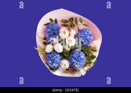 Bouquet de tulipes roses et de jacinthes violettes isolées sur fond violet. Vue de dessus. Banque D'Images