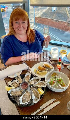 Femme mangeant des huîtres au restaurant Colmans Seafood Temple, Sea Road, South Shields, Tyne and Wear, Angleterre, Royaume-Uni Banque D'Images