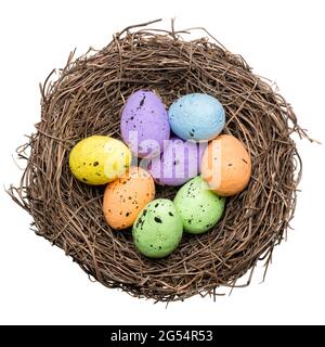 Groupe d'œufs de pâques colorés dans un nid d'oiseau, décoration saisonnière, isolé sur fond blanc Banque D'Images