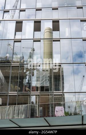 Reflet de l'une des cheminées emblématiques de la station électrique Battersea dans un mur de rideau de verre du nouveau bâtiment voisin. Banque D'Images