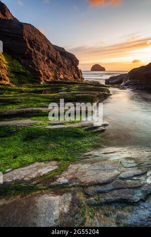 Coucher de soleil à Trebarwith Strand sur la côte nord de Cornwall, avec Gull Rock à l'horizon. Banque D'Images