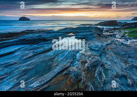 Coucher de soleil à Trebarwith Strand sur la côte nord de Cornwall, avec Gull Rock à l'horizon. Banque D'Images