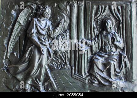 Cesate, Milan, Lombardie, Italie. Santuario della Beata Vergine delle Grazie (Sanctuaire de la Sainte Vierge des Grâces). Panneau de la porte d'entrée en bronze du sculpteur Giorgio Galletti (né en 1934) représentant des moments de la vie de la Vierge Marie, l'Annonciation à Marie par l'Archange Gabriel. Banque D'Images