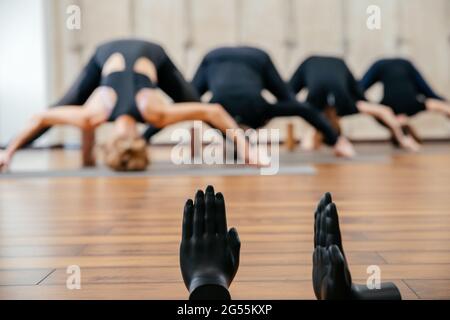 Groupe de femmes pratiquant l'étirement du yoga à l'aide de blocs de bois, exercice pour la flexibilité de la colonne vertébrale et des épaules Banque D'Images