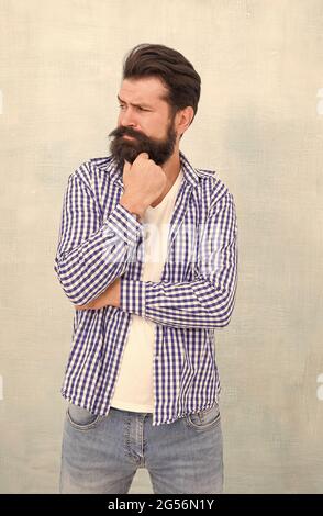 Perdu dans les pensées. Regard sérieux de l'homme barbu. Taille basse sérieuse avec fond bleu barbe. Résolution du problème. Dilemme. Processus de réflexion. Salon de coiffure Banque D'Images