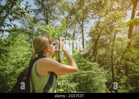 Une jeune femme observe les oiseaux avec des jumelles au parc national d'Indiana Dunes. Banque D'Images