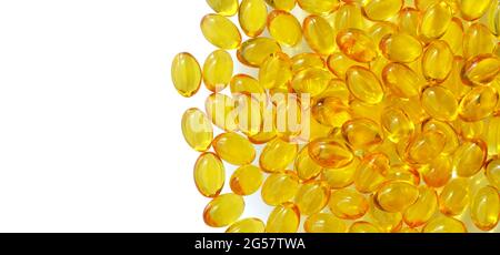 Capsules jaunes de vitamine E sur fond blanc avec espace de copie, vue du dessus. Concept de soins de santé. Banque D'Images