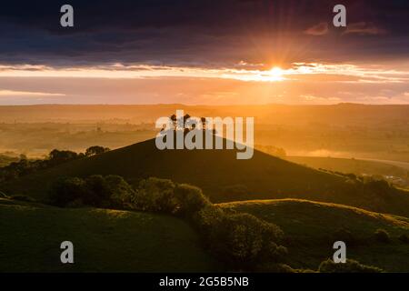 Bridport, Dorset, Royaume-Uni. 26 juin 2021. Météo Royaume-Uni. Un lever de soleil spectaculaire tandis que le soleil brille à travers une rupture dans les nuages au-dessus de Colmers Hill à Bridport dans Dorset. Crédit photo : Graham Hunt/Alamy Live News Banque D'Images