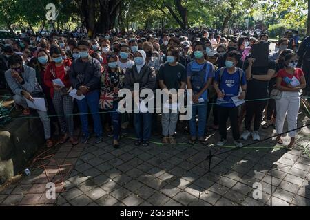 Denpasar, Bali, Indonésie. 26 juin 2021. Les gens se fient en attendant la vaccination gratuite. La police régionale de Bali effectue une vaccination de masse Covid-19 sur le terrain de Puputan Renon, en tant que police indonésienne pour cibler simultanément le mouvement ''1 million de vaccination' dans tout le pays. (Image de crédit : © Dicky BisinglasiZUMA Wire) Banque D'Images