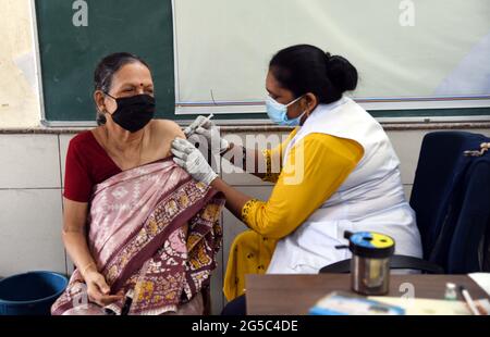 New Delhi, Inde. 25 juin 2021. Un agent de santé administre une dose du vaccin COVID-19 à une femme dans une école de New Delhi, en Inde, le 25 juin 2021. Credit: Partha Sarkar/Xinhua/Alamy Live News Banque D'Images