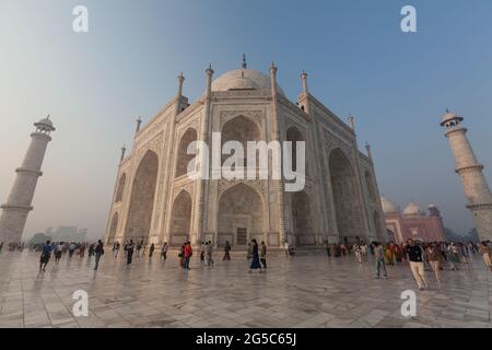 Un grand coup de touristes marchant autour de la terrasse du Taj Mahal au lever du soleil à Agra, Inde. Banque D'Images