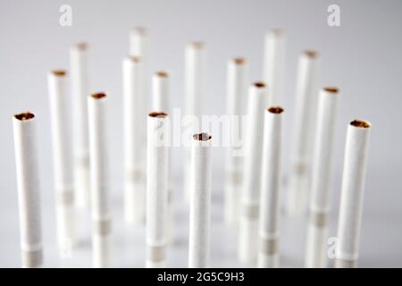 Gros plan d'une pile de cigarettes sur fond blanc Banque D'Images