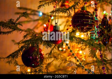 Nouvel an ou Noël en direct décoré avec élégance en épicéa gros plan - Jouets du nouvel an sur fond de branches vertes et feux Banque D'Images