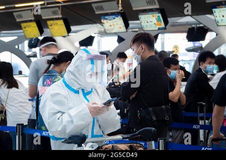 Bangkok, Thaïlande - 29 juin 2021 : passagers asiatiques portant une combinaison d'epi pour protéger contre le covid-19 ou le coronavirus pour s'enregistrer avant le vol à l'aéroport. Banque D'Images