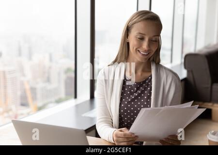 Bonne jeune femme d'affaires intelligente qui fait de la paperasse financière. Banque D'Images