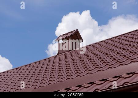 Tuiles de toit en métal, matériaux en acier toit de maison revêtu avec cheminée. Feuille de toiture de matériaux de construction Banque D'Images