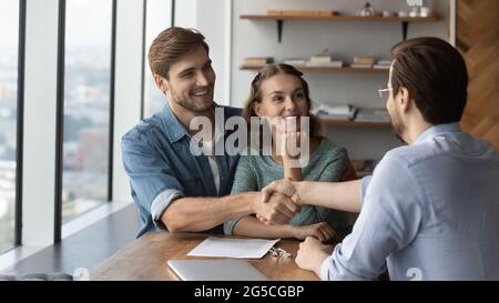 Heureux amoureux couple de famille marié serrer la main avec le realtor. Banque D'Images