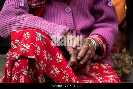 Gros plan sur les mains froissées croisées d'une grand-mère népalaise aînée. Banque D'Images