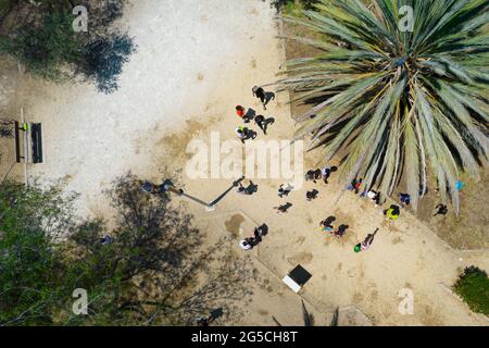 Enfants non reconnus jouant avec de l'eau dans le parc. Vue aérienne des gens qui s'amusent Banque D'Images