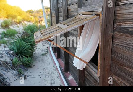 Maison de plage, fenêtres en bois ouvertes, chemin de sable menant à la mer en arrière-plan. Île tropicale Beach Resort Banque D'Images